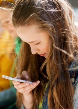 A group of teenagers focused on their cell phones. 