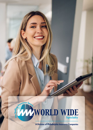 Smiling business woman uses a tablet while working on her insurance for staffing firms policy in the office. 