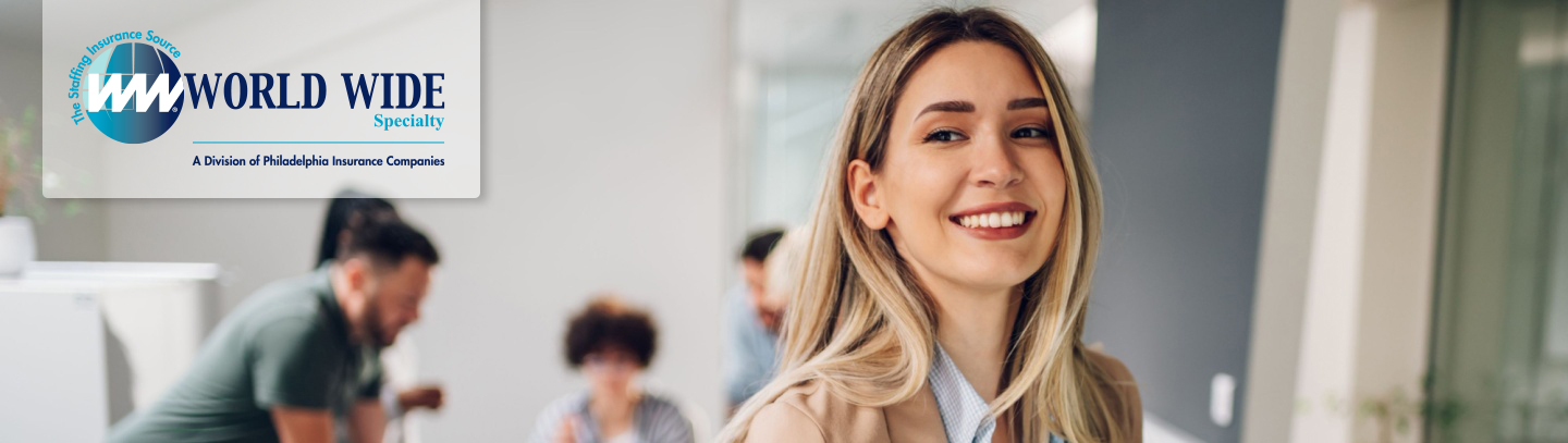 Smiling business woman uses a tablet while working on her insurance for staffing firms policy in the office. 