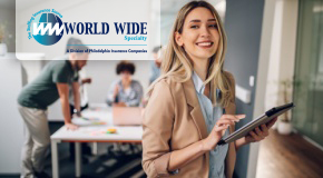 Smiling business woman uses a tablet while working on her insurance for staffing firms policy in the office. 